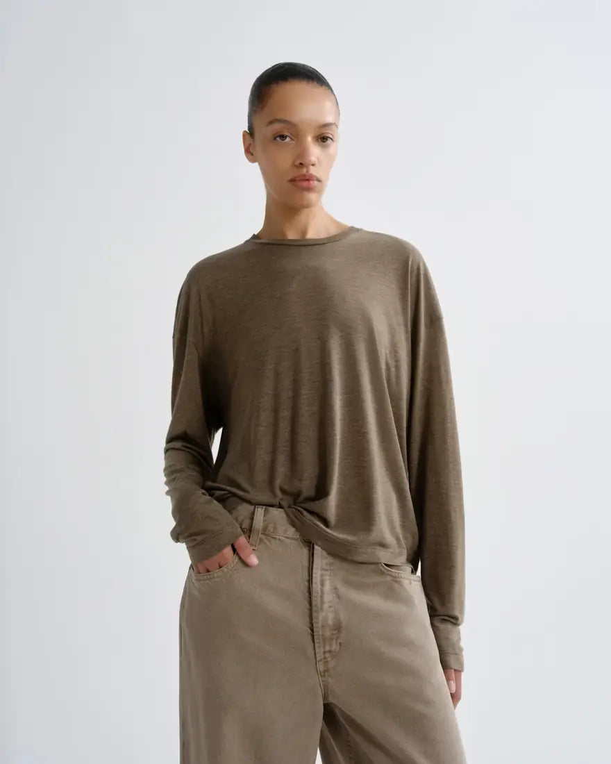 Model in a relaxed olive long-sleeve tee and taupe wide-leg jeans