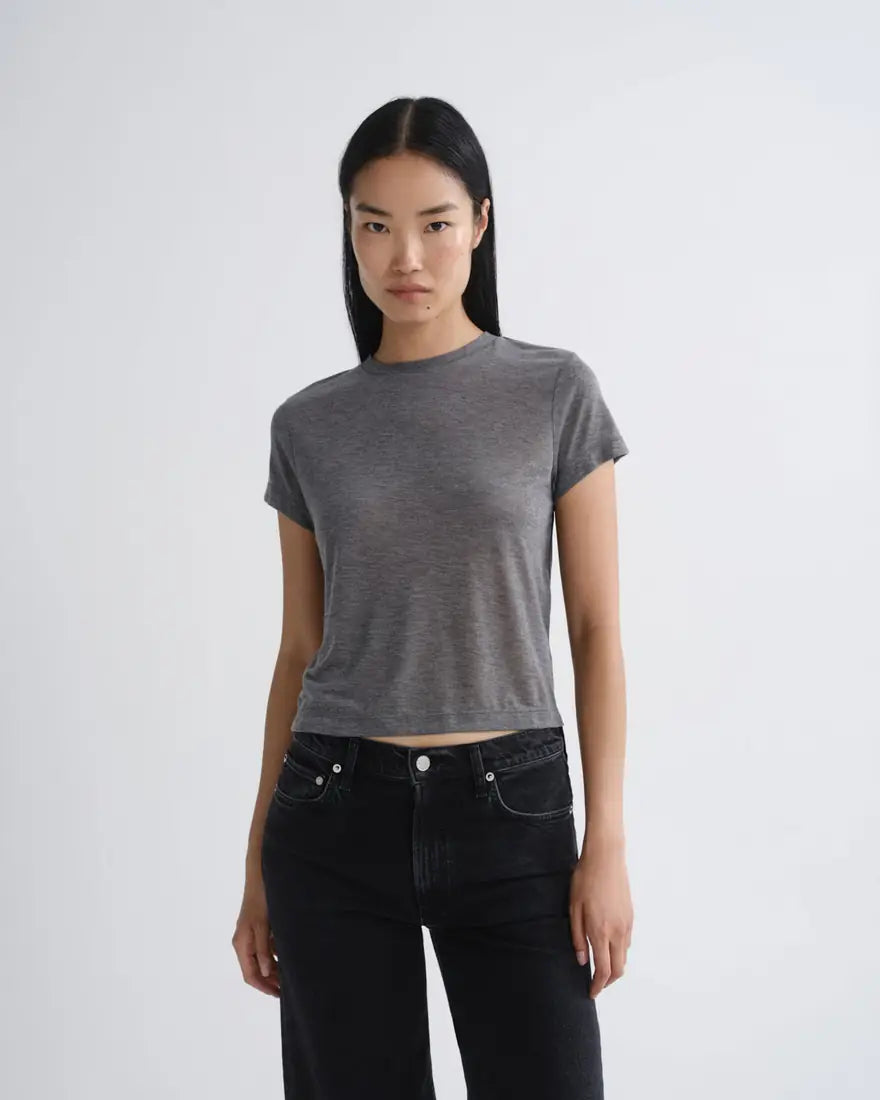 Model in a fitted grey tee and black jeans