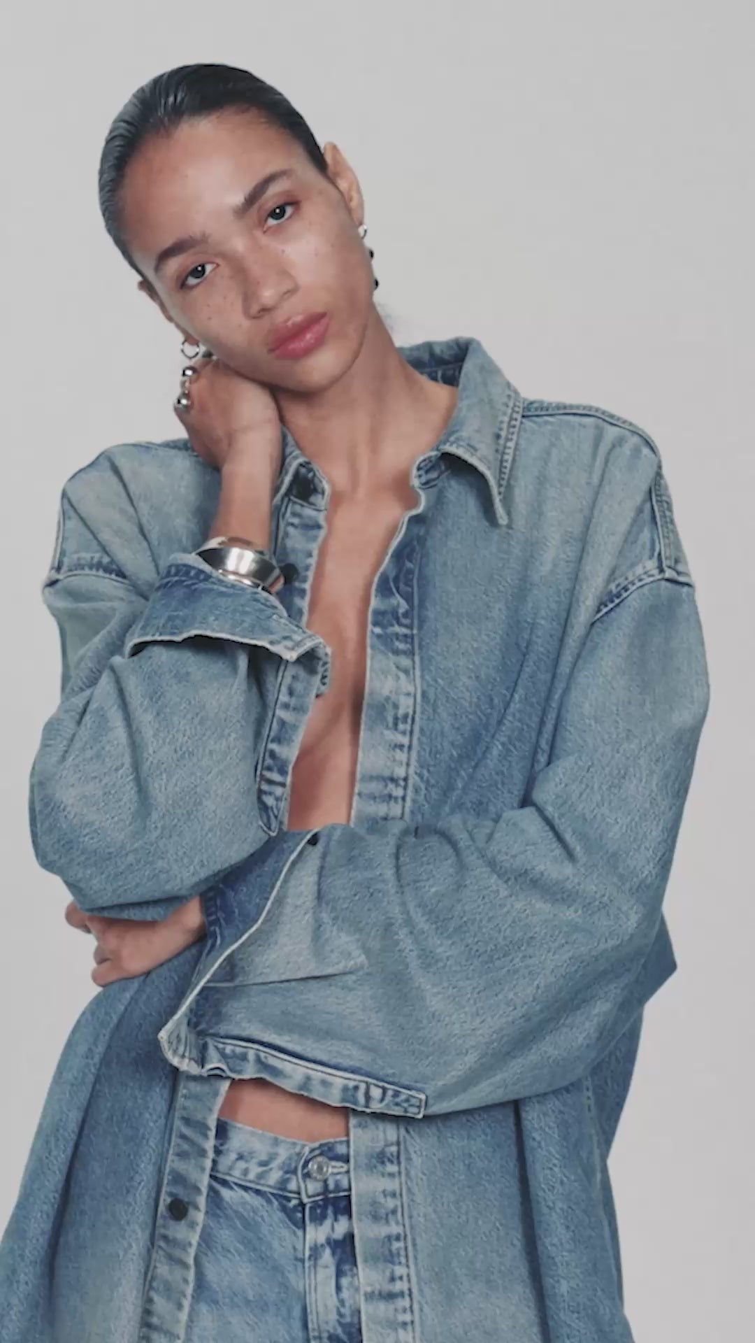 Model in an oversized AGOLDE denim shirt and jeans